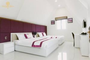 a bedroom with two beds and a purple headboard at Flower Hill in Da Lat +18 photos