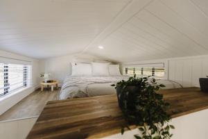 a bedroom with a bed and a wooden table at Yamba Tiny House Irene in Palmers Island