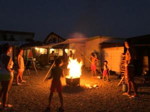 a group of people standing around a fire at night at Haryugetu Guesthouse in NASA in Kaiyo