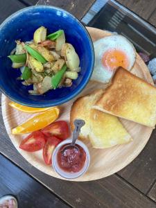 a plate of breakfast food with eggs toast and fruit at Haryugetu Guesthouse in NASA in Kaiyo