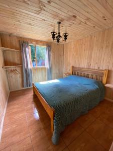 a bedroom with a bed in a wooden room at CABAÑAS RUCA MALAL in Futrono