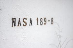 a sign that says nasa on a white wall at Haryugetu Guesthouse in NASA in Kaiyo