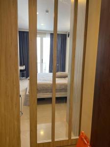 a room with a bedroom with a bed and a mirror at Xing Fave NagoyaThamrin City in Jodoh
