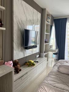 a bedroom with a tv on a marble wall at Xing Fave NagoyaThamrin City in Jodoh +1 photo