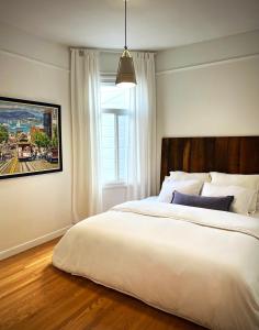 舊金山的住宿－Great bay views in Russian Hill district，卧室设有一张白色大床和一扇窗户。