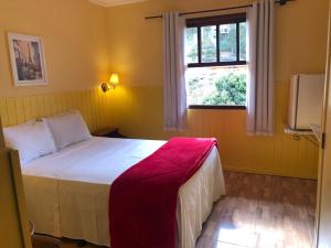 a bedroom with a bed and a window at VILLA MIA DUO in Itaipava