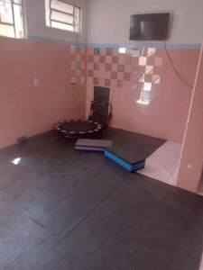an empty room with a chair and a table at Quarto com Duas Camas de casal in Vitória