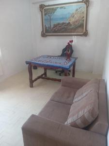 een woonkamer met een bank en een tafel bij Quarto com Duas Camas de casal in Vitória