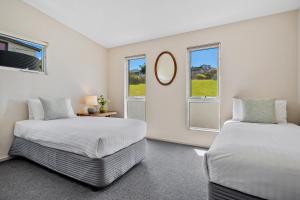 two beds in a room with two windows at Manfield Seaside Bruny Island in Alonnah