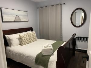 a bedroom with a bed with a mirror and towels at Casa Azul-lakefront in Leamington