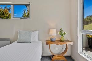 a bedroom with a bed and a window at Manfield Seaside Bruny Island in Alonnah