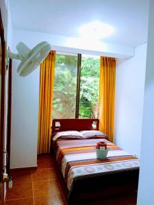 ein Schlafzimmer mit einem Bett und einem großen Fenster in der Unterkunft Confort Putumayo in Mocoa