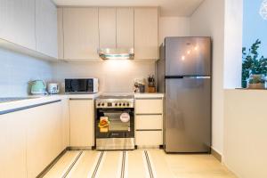 a kitchen with a stove and a refrigerator at Voyage's Stylish 1br At Waters Edge in Abu Dhabi +21 photos