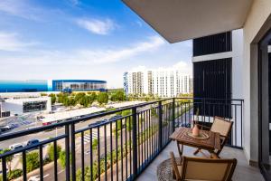 a balcony with a table and chairs and a view of the ocean at Voyage's Stylish 1br At Waters Edge in Abu Dhabi