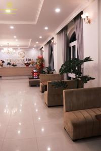 a lobby with couches and plants in a building at Flower Hill in Da Lat