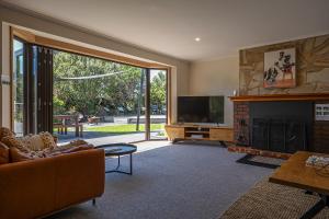 uma sala de estar com televisão e lareira em Lumeah Retreat Bruny Island em Adventure Bay