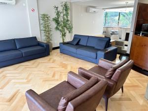 sala de estar con sofás azules y sofá en Job&Joy Business Hostels en Campinas