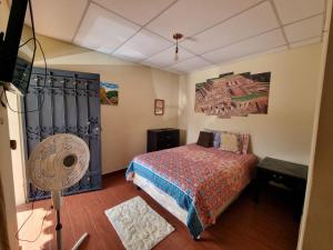 a bedroom with a bed and a fan at Hostal Las Veraneras Ataco in Concepción de Ataco
