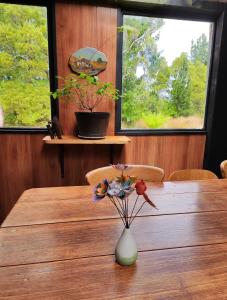 uma mesa de madeira com um vaso com flores em Glamping at Zeehan Bush Camp em Zeehan