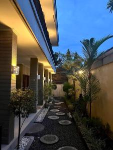 un patio con un camino con plantas y un edificio en Amigos Guesthouse & Hostel, en Canggu