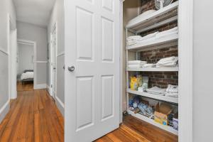 a hallway with a white door and a brick wall at The Maverick Downstairs - Lux Apartment - Free Parking - 2 Miles From Airport & Downtown Boston in Chelsea +18 photos