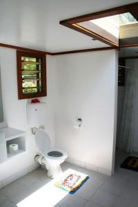 a bathroom with a toilet and a window at Mana Backpackers and Dive Resort in Mana Island