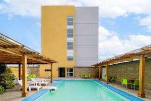 a swimming pool with chairs and a building at City Express by Marriott Salina Cruz in Salina Cruz