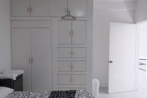 Habitación blanca con armarios blancos y cama en Casa con Alberca adentro cerca de Las Estacas, 