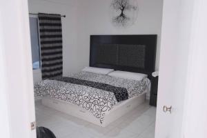 łóżko z czarno-białą kołdrą w pokoju w obiekcie Casa con Alberca adentro cerca de Las Estacas 