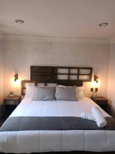 1 dormitorio con 1 cama blanca grande y 2 lámparas en Añoranza Hotel Boutique, en Ciudad Hidalgo