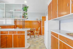 a kitchen with wooden cabinets and a white refrigerator at #9 Dream in Rotorua