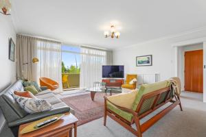 a living room with a couch and a tv at #9 Dream in Rotorua