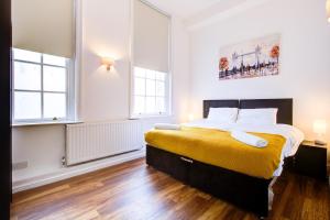 um quarto com uma cama grande e 2 janelas em London Central em Londres