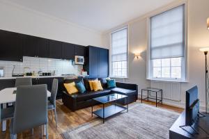 a living room with a couch and a kitchen at London Central in London