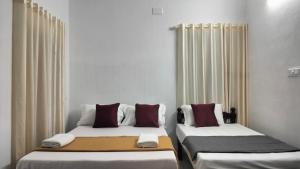 dwa łóżka siedzące obok siebie w pokoju w obiekcie KOVIL home's Guest land w mieście Koczin