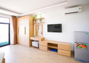 a living room with a tv on a wall at An Dương Hotel & Apartment in Da Nang