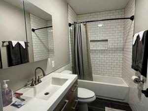 La salle de bains est pourvue d'un lavabo, de toilettes et d'une baignoire. dans l'établissement Downtown Albany 2 Bedroom + Workstation @ The Mark, à Albany