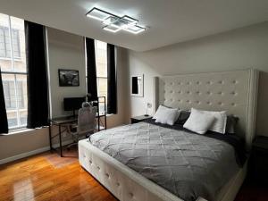 a bedroom with a large bed in a room with windows at Downtown Albany 2 Bedroom + Workstation @ The Mark in Albany