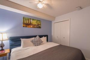 - une chambre avec un lit et un ventilateur de plafond dans l'établissement Mountain View One Bedroom Vacation Suite - WindTower 119, à Canmore