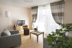 a living room with a couch and a table at Domitys La Clef des Champs in Poitiers