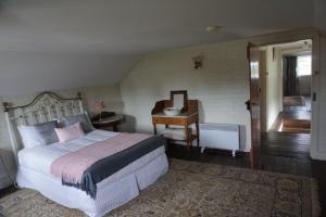 um quarto com uma cama, uma secretária e um piano em Woolmers Estate em Longford