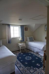 LongfordにあるWoolmers Estateのベッド2台と窓が備わるホテルルームです。