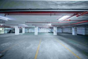 an empty parking garage with white columns and lights at 台中灣文旅 T C ONE Hotel in Taichung