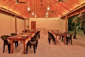 a large dining room with wooden tables and chairs at Sunny Breeze View in Hangnaameedhoo