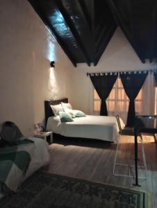 Un dormitorio con una gran cama blanca y una ventana en Cabañas las palmeras en Don Torcuato