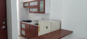 a kitchen with brown cabinets and a white refrigerator at Apartaestudio cerca al parque principal in Los Andes