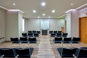 a conference room with chairs and a projection screen at City Express Plus by Marriott Mexicali in Mexicali +42 photos