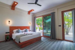 a bedroom with a large bed and a large window at Sunny Breeze View in Hangnaameedhoo