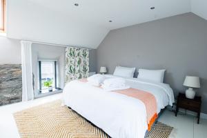 a white bedroom with a large bed with towels on it at Stone Barn in Skibbereen
