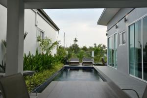 Green Lung Pool Villas Bangkok في Bang Krasop: اطلالة خارجية على منزل به مسبح